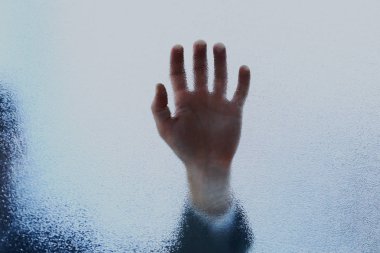 Bir avuç dolusu kumlu cam levhaya yaslanmış..