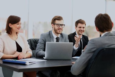 Bir grup iş ortağı ofiste fikir alışverişinde bulunuyor..