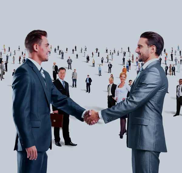 Shaking hands on a background of a large group of people — Stock Photo, Image