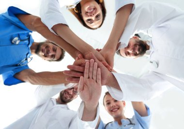 En alttaki görüntüde. Tıp merkezindeki bir grup doktor ellerini birbirine yapıştırdı.