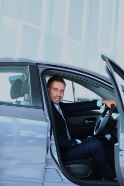 Genç adam araba salonunda seçme.