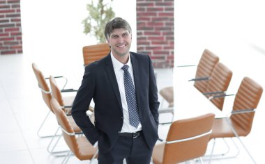 Bir boş toplantı odasında duran iş adamı