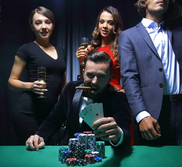 Rich handsome man smoking cigar and playing in the casino — Stock Photo, Image