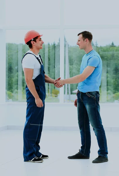 Клієнт тремтить руками з будівельником . — стокове фото