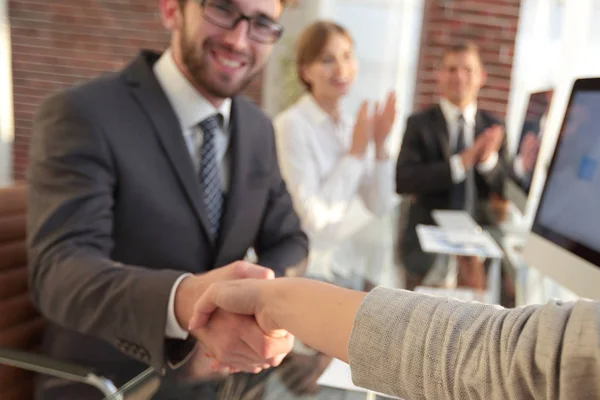 Affärsman som skakar hand med en affärspartner som sitter nära skrivbordet — Stockfoto