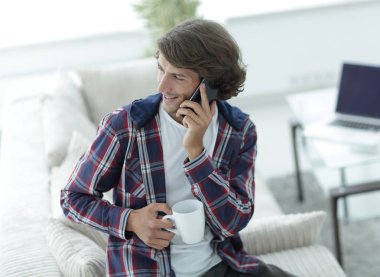 güzel bir fincan adamla bir dizüstü bilgisayar önünde oturur.