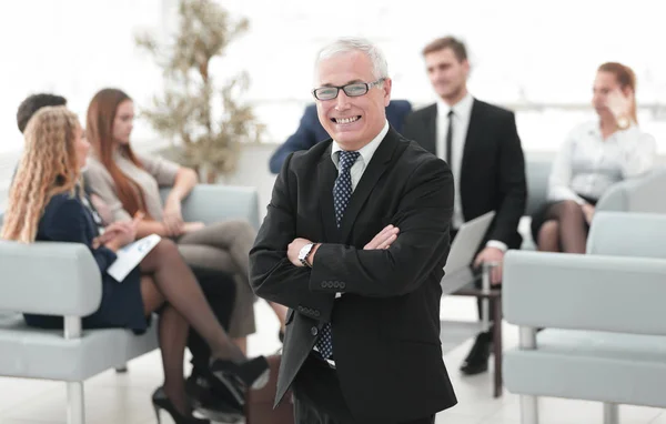 Leende senior affärsman på bakgrunden av business-team — Stockfoto