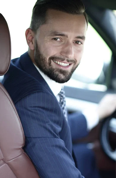 Handsome young man sitting in the front seat of a car looking at the camera — Stock Photo, Image