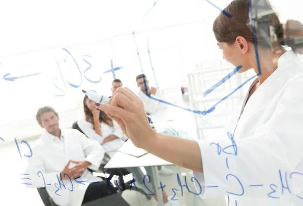 View through the transparent Board. female biochemist makes a report to colleagues — Stock Photo, Image