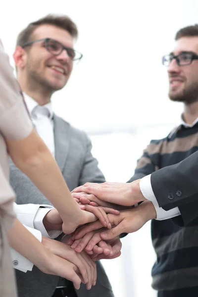 Collega's met hun handen elkaar gestapeld — Stockfoto