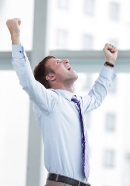 Businessman celebrating with his fists raised in the air clipart