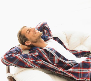 Modern adam büyük bir rahat sandalyede oturuyor dinleniyor. yan görünüm.