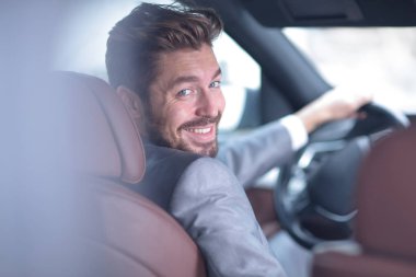 Başarılı bir adam prestijli bir arabanın direksiyonunda oturuyor.