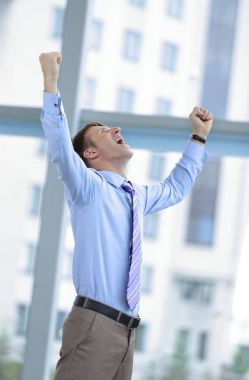Businessman celebrating with his fists raised in the air clipart