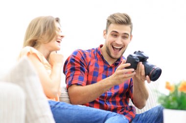 Modern genç çift gülüyor ve kameradaki fotoğrafları tartışıyor.