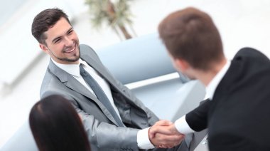 Ofisin lobisinde el sıkışan iş ortakları..