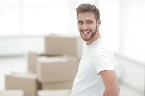 Усміхнений чоловік стоїть в новій квартирі — стокове фото