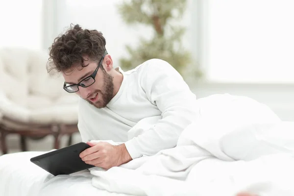 closeup.sleepy man looking at the screen of a digital tablet.