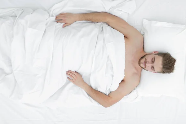 Junger Mann Entspannung auf dem Bett Draufsicht — Stockfoto