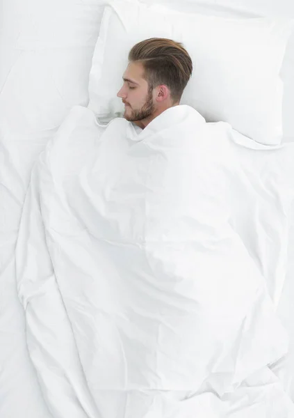 View from the top.smiling man lying on a comfortable mattress — Stock Photo, Image