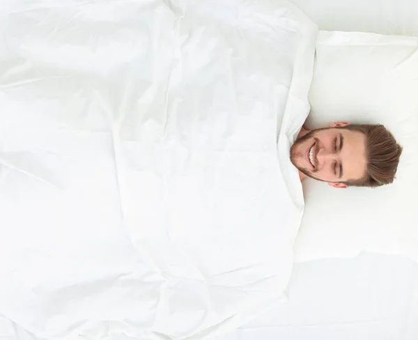 View from the top.smiling man lying on a comfortable mattress — Stock Photo, Image