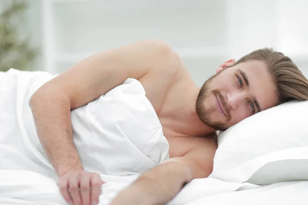 Щасливий чоловік, засинає в зручному ліжку — стокове фото