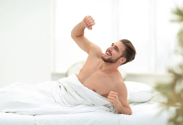 Sorrindo homem acordando em um quarto acolhedor — Fotografia de Stock