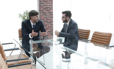 iki işadamı görevleri Office masada oturan tartışıyor.