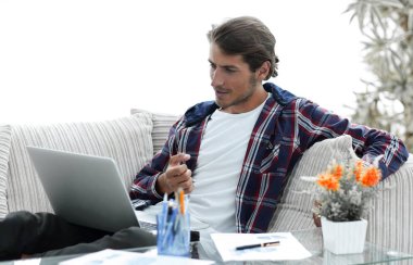 şaşırmış genç adam evden dizüstü bilgisayar ile çalışma.