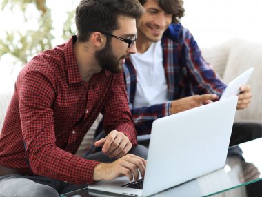 İki web tasarımcıları bir proje bir dizüstü bilgisayar önünde tartışmaya portresi