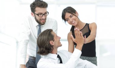 Birbirimizi bir beşlik veren genç iş arkadaşları