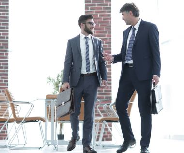 İki işadamları boyunca modern ofis binası içinde yürüyüş