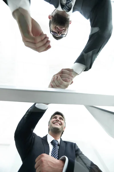 Spodní pohled. Zpoza skla. Handshake obchodních partnerů — Stock fotografie