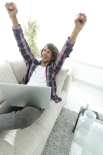 Mycket glad kille arbetar med laptop hemma. — Stockfoto