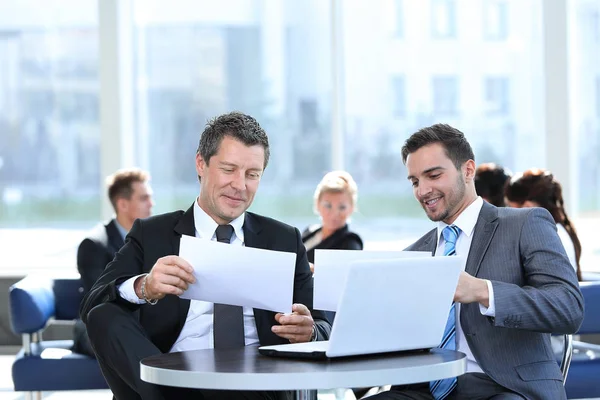 Socios de negocios discutiendo un nuevo proyecto, sentado en el vestíbulo de la oficina. — Foto de Stock