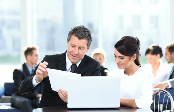 Socios comerciales discutiendo documentos, sentados a la mesa . — Foto de Stock