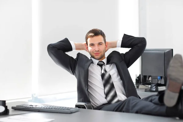 young businessman relaxes sitting at his Desk.