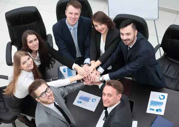 Бізнес-команда з руками, закріпленими разом на столі — стокове фото