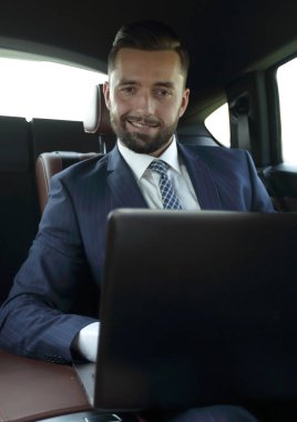 Bir arabanın arka koltuğunda oturan başarılı adam