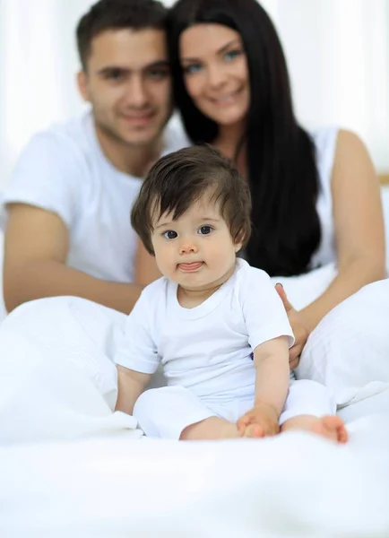 Happy couple and son sitting in bed — Stock Photo, Image