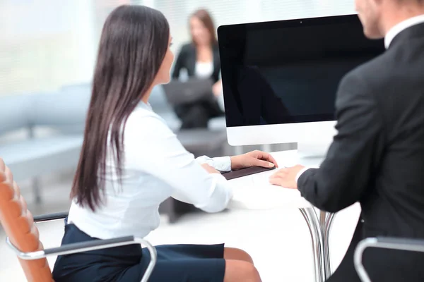 Rückansicht: Zwei erfolgreiche Mitarbeiter sitzen hinter einem Schreibtisch — Stockfoto