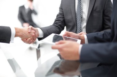 Bir toplantı sırasında el sıkışan iki emin iş adamları