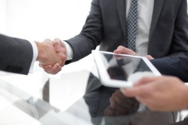 Bir toplantı sırasında el sıkışan iki emin iş adamları