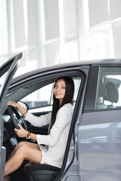 Mujer de negocios moderna sentada detrás del volante de un coche, en el aparcamiento — Foto de Stock