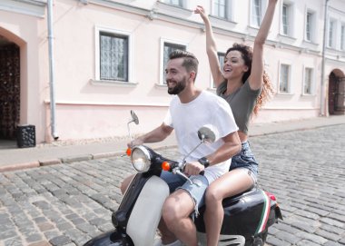 mutlu genç bir çift bir scooter üzerinde eğleniyor