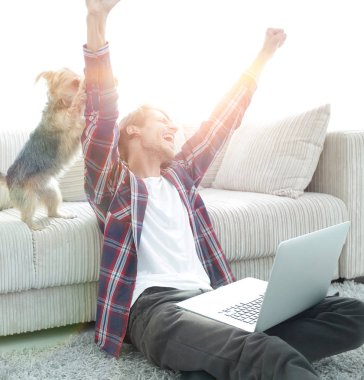 sevindirici ve yakın oturma odasında kanepede oturan ellerini yükselterek mutlu adam.