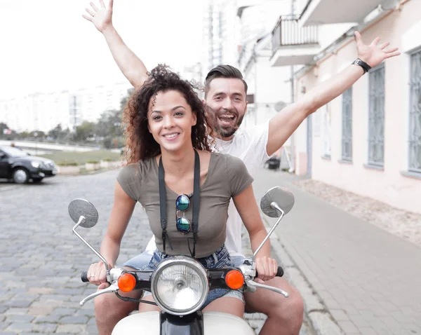 Couple riding motor scooter in old city street. — Stock Photo, Image