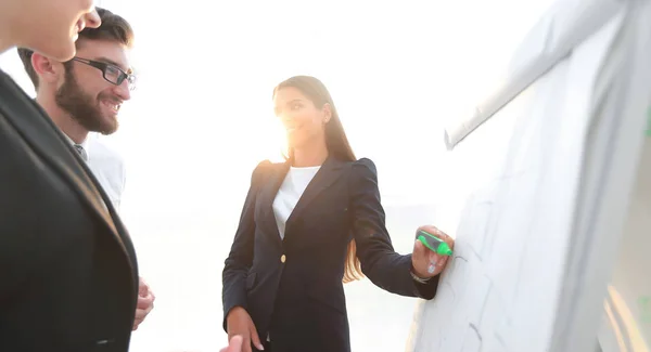 Femme d'affaires pointant avec un marqueur sur le tableau à feuilles — Photo