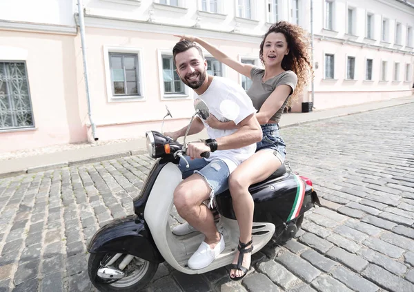 Vrolijke jonge paar rijden een scooter en plezier — Stockfoto