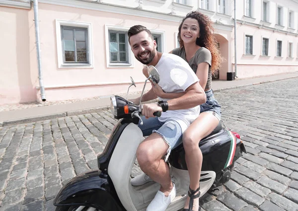 Vrolijke jonge paar rijden een scooter en plezier — Stockfoto